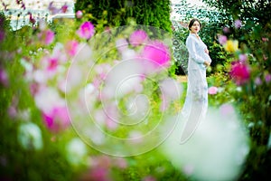 Pregnant country women in a white dress walks in the garden