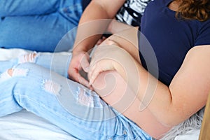 A pregnant couple embraces a woman with a stomach, close-up. Close-up of a human couple holding a pregnant belly in