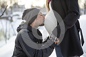 Pregnant couple have fun in winter nature