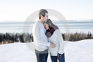 Pregnant couple have fun in winter nature