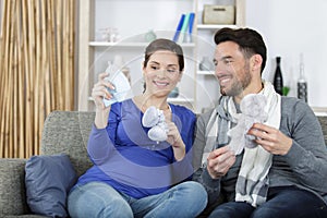 pregnant couple holding baby cloths