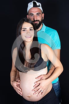 Pregnant couple husband touching his wife belly with hands