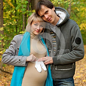 Pregnant couple posing with baby socks