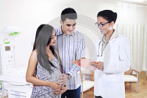 Pregnant couple visiting a female doctor