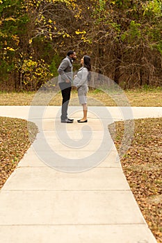 Pregnant Couple Walking And Holding Hands at the park