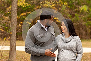 Pregnant Couple Walking And Holding Hands at the park