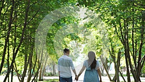 Pregnant Couple Walking in Summer Park