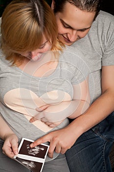 Pregnant couple is watching their echo