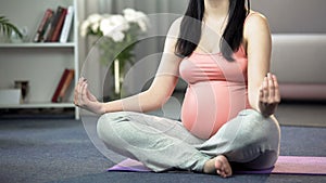Pregnant doing lotus pose yoga for future mum caring about mental health of baby