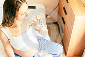 Pregnant drinking water. Young pregnancy mother drink water. Pregnant lady waiting of baby. Glass of water. Concept