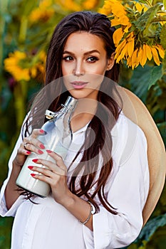 Pregnant european woman in a field of sunflowers, beautiful young european woman waiting for a child, prenant woman with