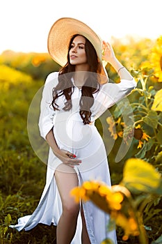 Pregnant european woman in a field of sunflowers, beautiful young european woman waiting for a child, prenant woman with