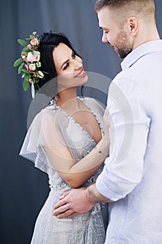 Pregnant european woman with her husband on gray background, young european couple waiting for a child, prenant woman