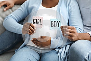 Pregnant family holding color cards for baby boy or girl