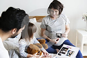 Pregnant family looking through a family photo album