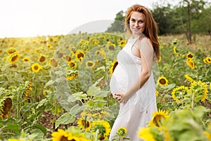 Pregnant fashion girl in sunflowers field