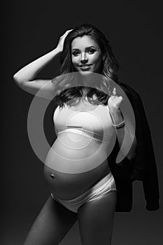 Pregnant female model in sports underwear standing and posing