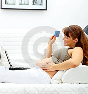 Pregnant female using credit card to shop from net