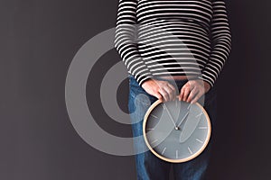 Pregnant female with vintage alarm clock