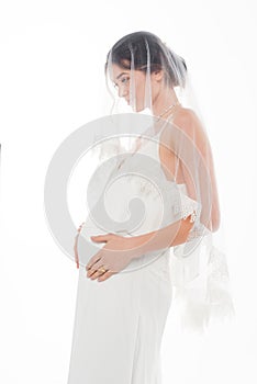 pregnant fiancee in veil touching tummy