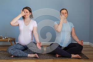 Pregnant fitness person practicing yoga at home. Prenatal Pranayama.