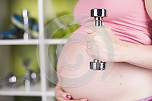 Pregnant Fitness Woman with dumbbells