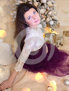 Pregnant girl in a beautiful interior studio celebrates Christmas