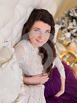 Pregnant girl in a beautiful interior studio celebrates Christmas