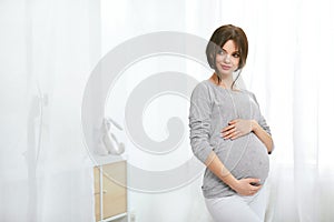 Pregnant Girl. Beautiful Smiling Pregnant Woman At Home