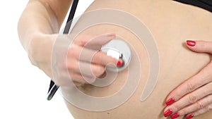 Pregnant girl being examine with stethoscope, white, closeup