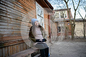 Pregnant girl on the bench. A pregnant young girl is sitting on a bench. The concept of the beginning of autumn and fall of leaves