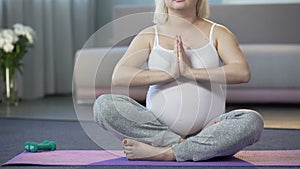 Pregnant girl doing yoga before giving birth to calm baby and reduce labor pains