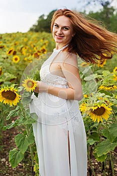 Pregnant girl in the field with sunflowers