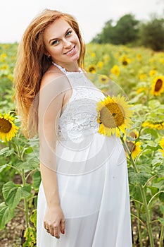 Pregnant girl in the field with sunflowers