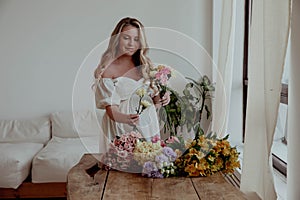 Pregnant girl with flowers in a light dress
