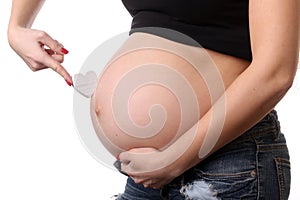 Pregnant girl with heart symbol. Close up. White background