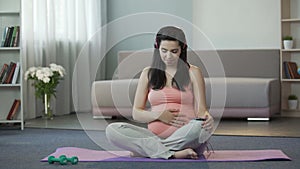 Pregnant girl listening to melodies engaging in spiritual development of fetus