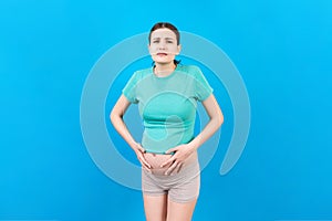 A pregnant girl who has a stomach ache stands on a colored background. isolated