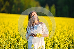 Pregnant girl on a yellow background. looks at his stomach, imagines his unborn child. Maternity concept