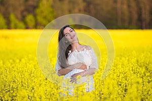 Pregnant girl on a yellow background. looks at his stomach, imagines his unborn child. Maternity concept