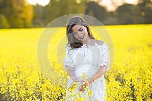 Pregnant girl on a yellow background. looks at his stomach, imagines his unborn child. Maternity concept