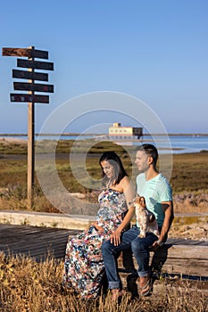 Pregnant happy couple with small dog