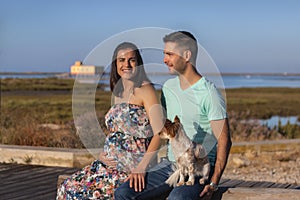 Pregnant happy couple with small dog