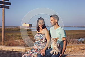 Pregnant happy couple with small dog