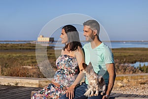 Pregnant happy couple with small dog