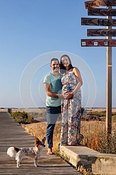 Pregnant happy couple with small dog