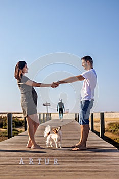 Pregnant happy couple with small dog