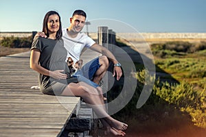 Pregnant happy couple with small dog