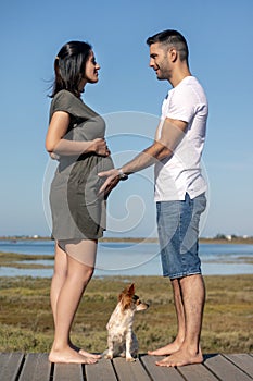 Pregnant happy couple with small dog