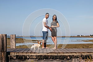 Pregnant happy couple with small dog